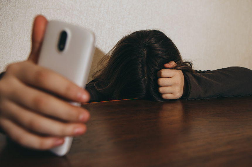 CyberbullyingTeen Girl Excessively Sitting At The Phone At Home. He Is A Victim Of Online Bullying Stalker Social Networks - ImageCyberbullying